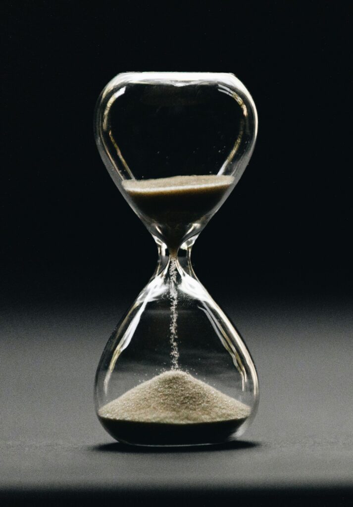 Clear hourglass with falling sand – time lost to compulsive habits