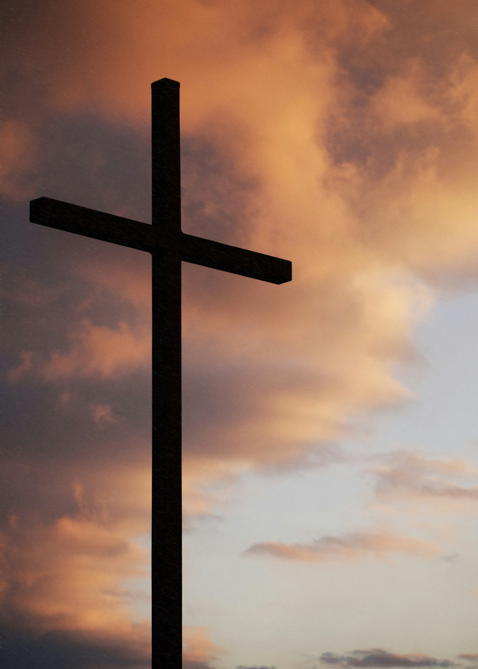 Silhouette of a large cross under an orange sky – faith and hope in recovery