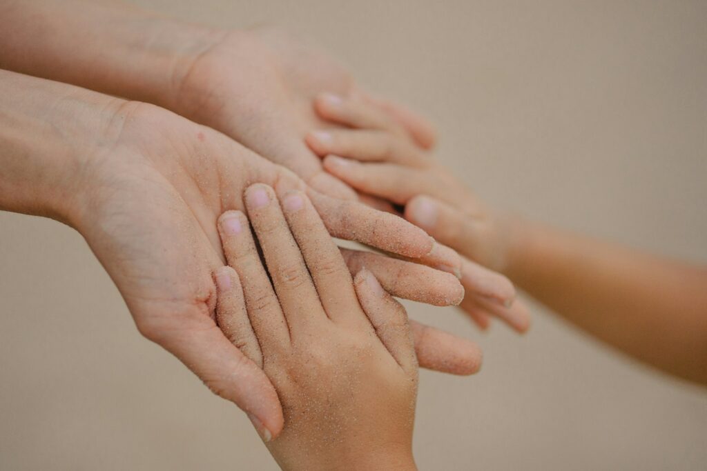 Hands of different sizes layered together – healthy family support