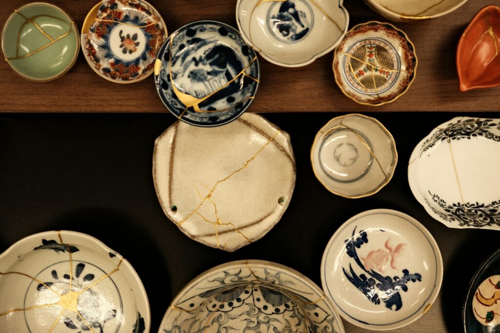 Ceramic dishes repaired with gold kintsugi seams – broken pieces made whole