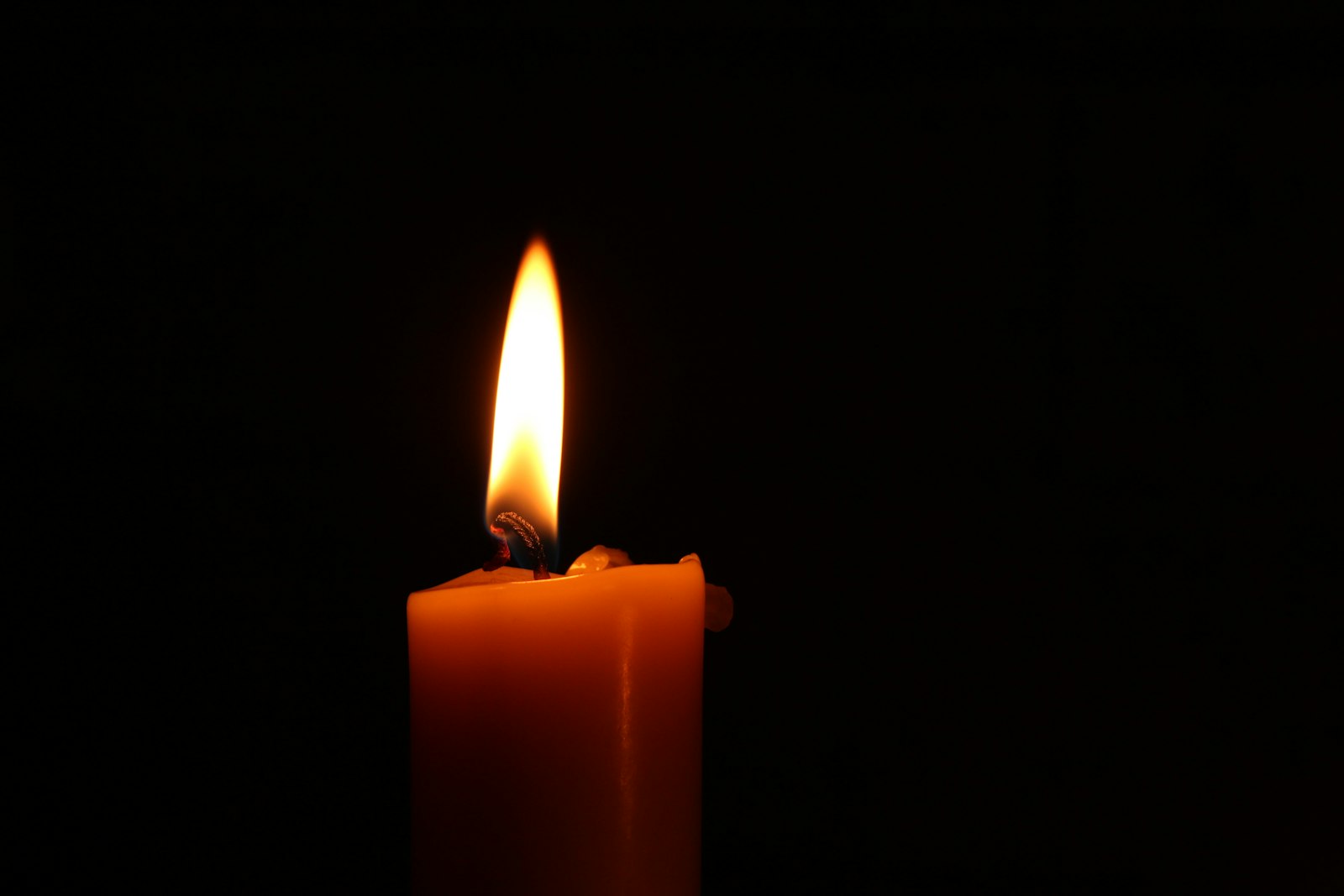 Close-up of a lit memorial candle – grieving the loss of a loved one