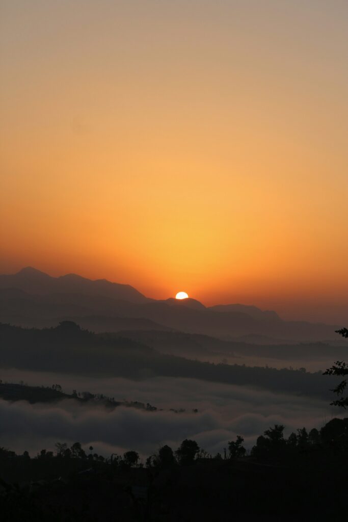 Low sun rising over misty mountain ridges – a new day in sobriety